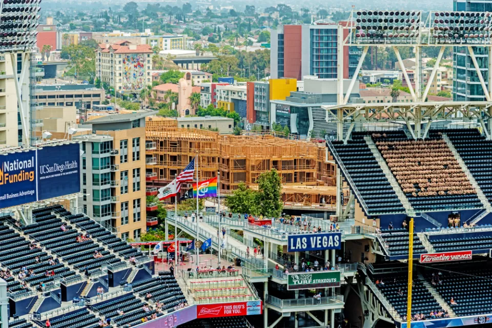 An image of stadium seats at Petco Park in San Diego, with new buildings under construction nearby in the background.